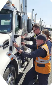 Supportive truck driving school instructors helping students with hands-on training
